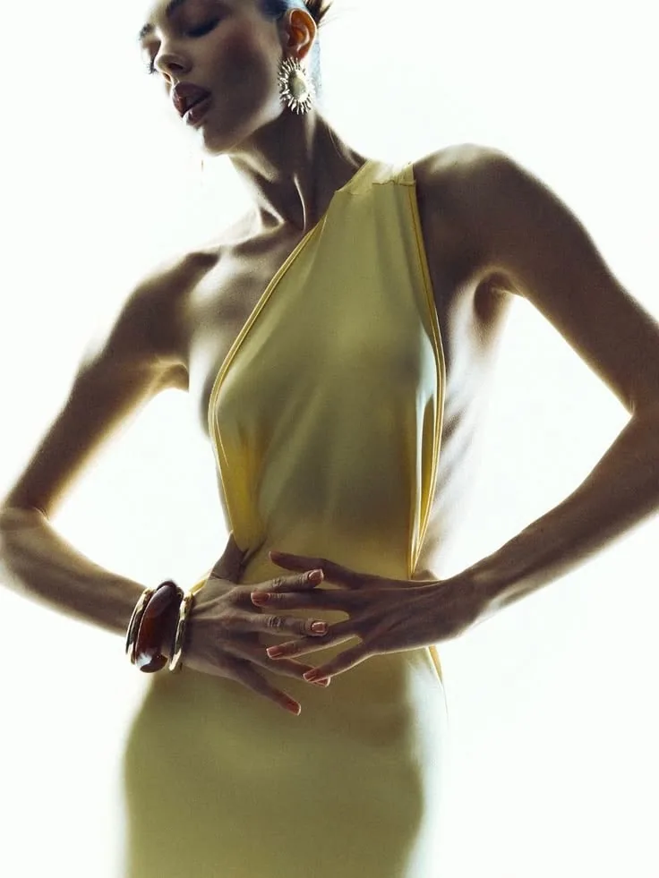 Model in a chartreuse halter dress against a white backdrop